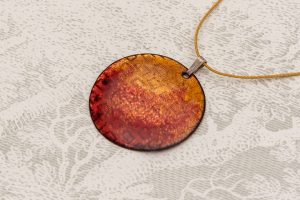 Esmalte con texturas color naranja. Cordón de seda japonesa